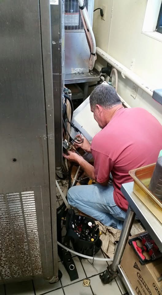 Technician servicing commercial refrigeration equipment